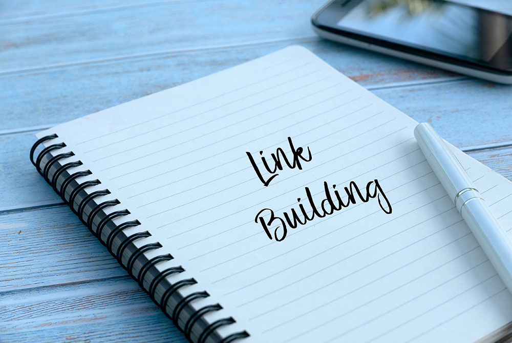 Link Building shown on a writing pad in black writing.